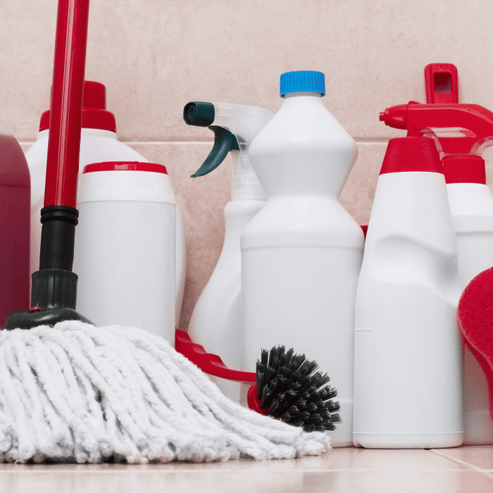 collection of bathroom cleaning supplies against a tile wall