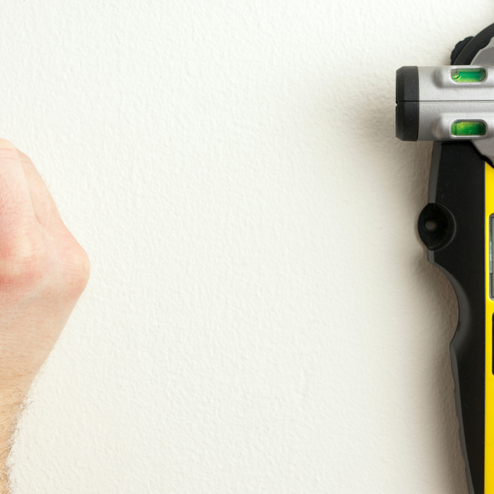 laser stud finder against a white wall