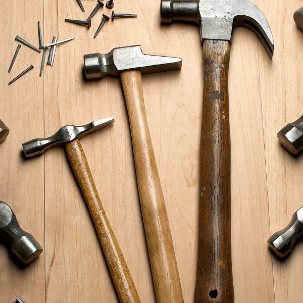 a selection of hammers laying flat on a wooden table