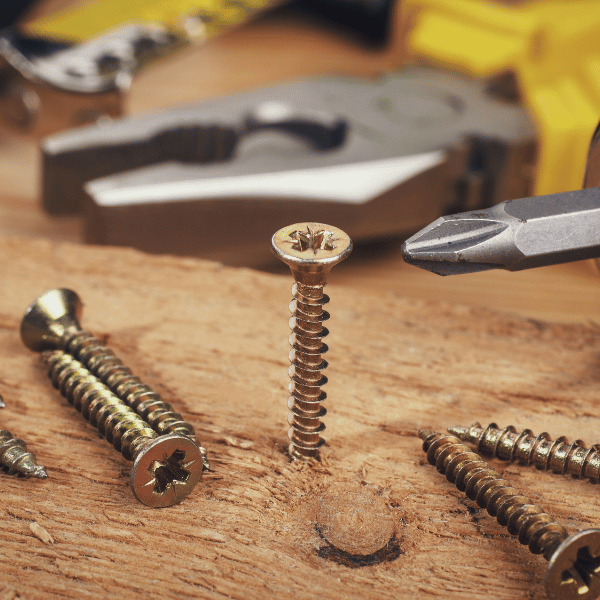 closeup of wood screws and a drill